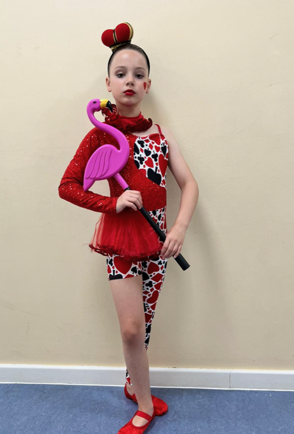 girl with costume on holding a flamingo on a stick