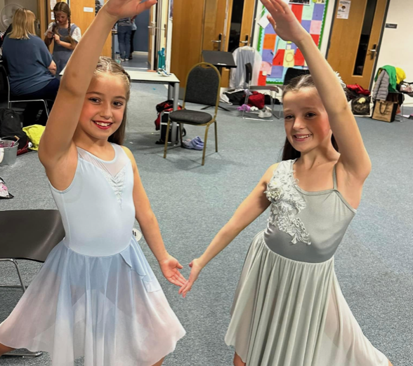 two girls in ballet uniform doing diamond pose