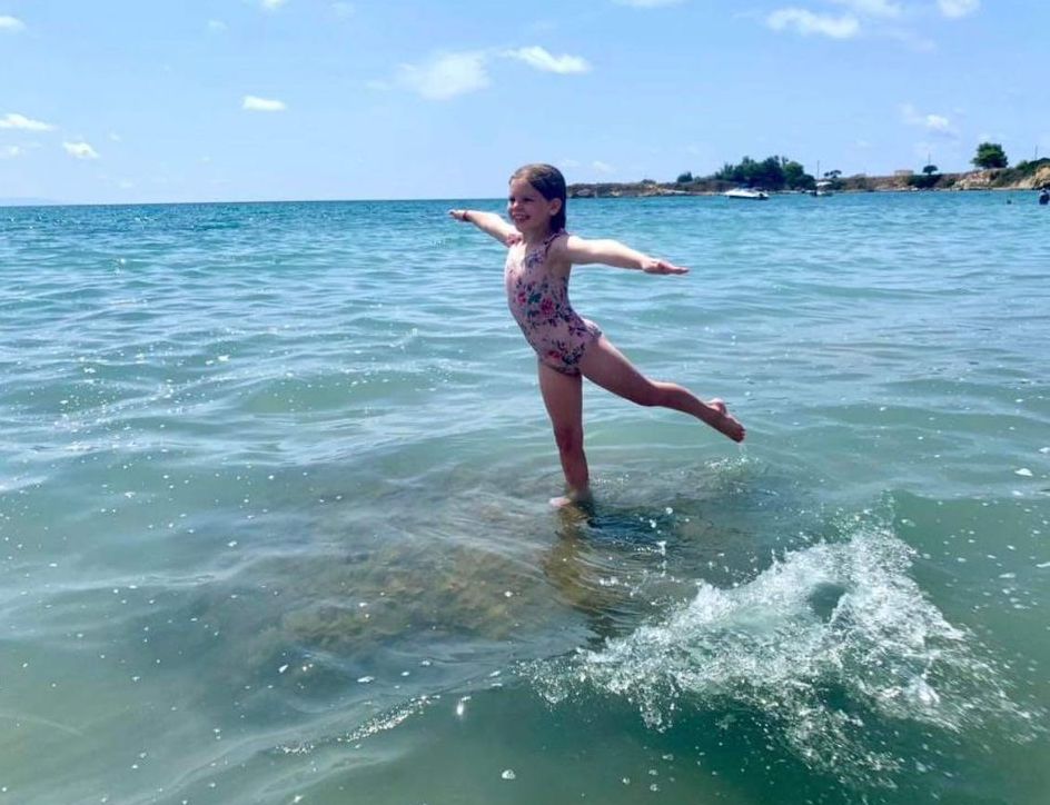 girl does ballet pose in sea